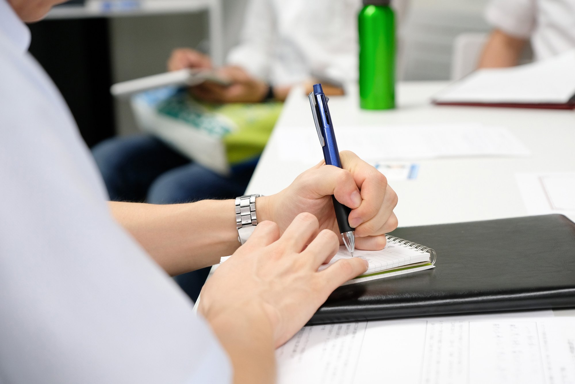 A Japanese businessman taking notes at a seminar.